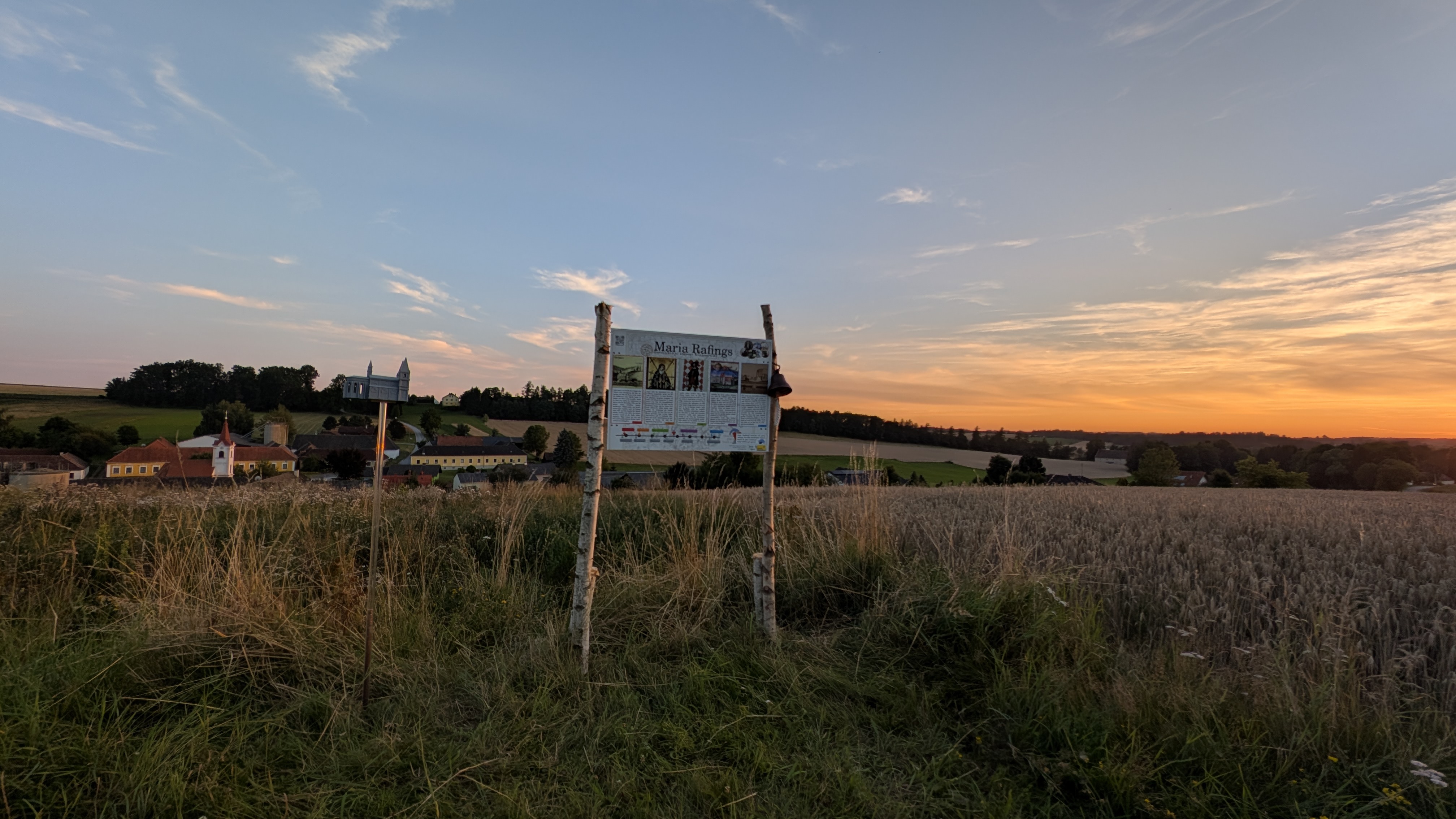 Beobachtungsplatzl, Feld mit Schautafel, bei Sonnenuntergang 