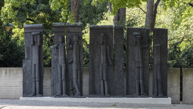 Eine Fotografie des siebenteiligen Figurenreliefs von Fritz Wotruba, die die Skulptur im Skulpturengarten des Belvedere 21 zeigt.