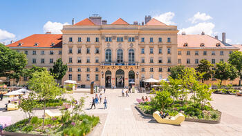 Blick über den begrünten Haupthof des MuseumsQuartier Wien auf den Fischer-von-Erlach-Trakt.