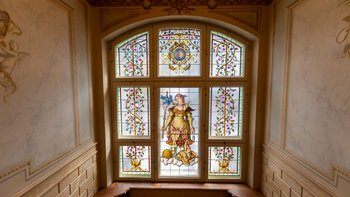 Bleiverglastes, bemaltes Fenster im Treppenaufgang der Villa Franziska und Iwan Rosenthal. Zeigt Frauenfigur im prächtigen Gewand.