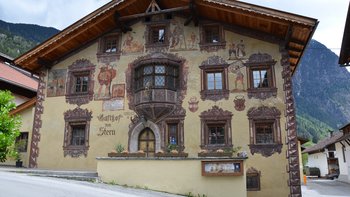 Die bemalte Nordfassade des Gasthofs zum Stern in Oetz zeigt Wandmalereien, einen Erker und die Inschrift „Anno 1573“.