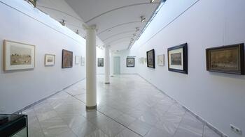 Blick in die Galerie. Sicht auf die 3 Säulen, von deren Kapitellen sich die schiffsrumpfanmutende Decke zu beiden Seiten erstreckt.