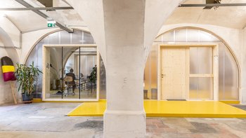 In die Gewölbestruktur sind geschlossene Kuben, die das Stadtteilbüro mit der dazugehörigen Infrastruktur beinhalten, eingeschoben.