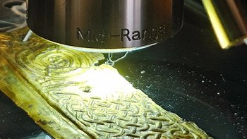 Ein Teil der vergoldeten Kupferverkleidung des Rupertuskreuzes wird unter dem 3-D-Mikroskop untersucht.