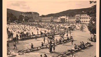 Blick auf den Sandstrand mit Menschen in Badekleidung; dahinter das Hotel Esplanade; Schwarzweißfoto.