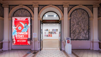 Blick vom Stiegenhaus in die Ausstellung mit Ausstellungssujet