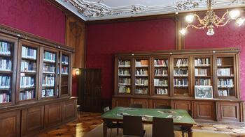 Einblick in einen historischen Raum mit Tisch und Bücherschränken