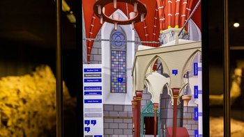 Digitale Rekonstruktion eines mittelalterlichen Synagogenraum mit Buntglasfenster und gotischen Bögen auf einem Bildschirm