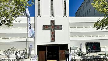 Das Kirchengebäude spannt sich zwischen zwei Wohnbauten und wurde als Hauskirche geplant.