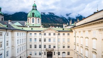 Innenhof Hofburg Innsbruck im Hintergrund wolkenverhangene Berge