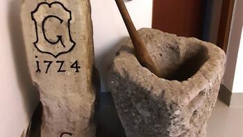 Historischer Grenzstein und römische Handmühle